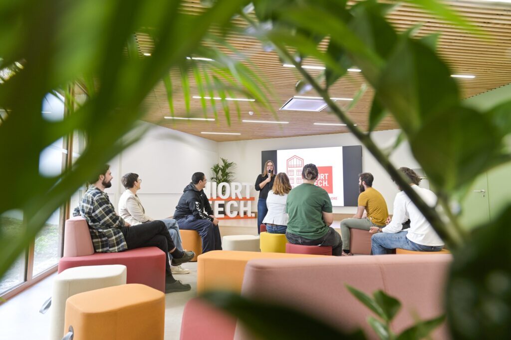 Une dizaine de personnes réunies dans le salon de Niort Tech autour d’une intervenante au micro, devant un écran