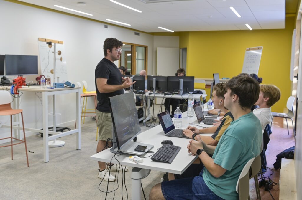 Un atelier de fabrication : un encadrant et des étudiants devant leurs écrans