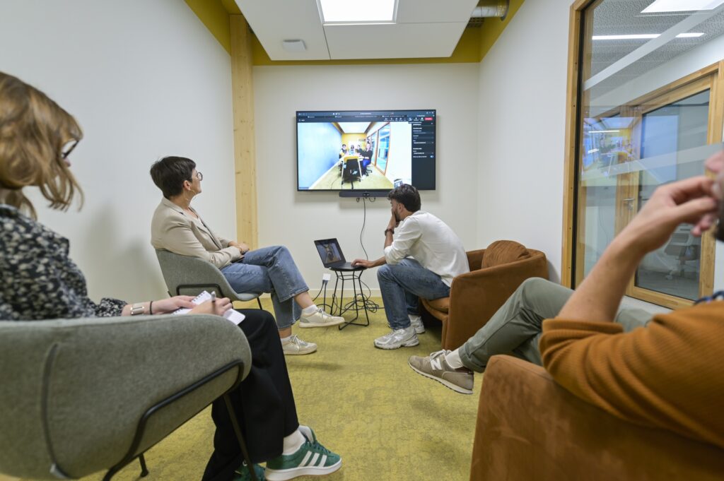 Un petit groupe en fauteuils suit une présentation à l’écran