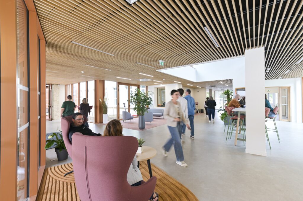 Le hall sous sa charpente de bois, avec ses fauteuils et ses tables hautes
